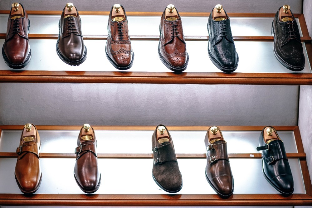 Bunch of classy mens shoes on display inside a retail store.