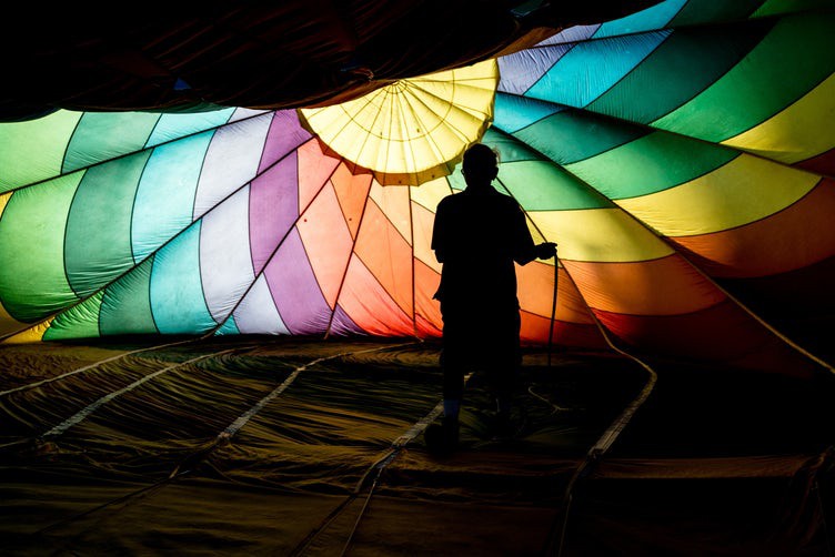 shadow silhouette of a man setting up a hot air balloon