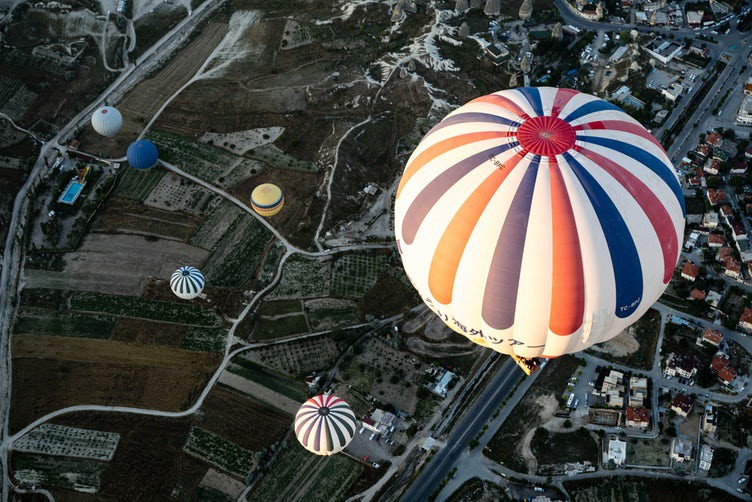 Looking down at multiple hot air balloons