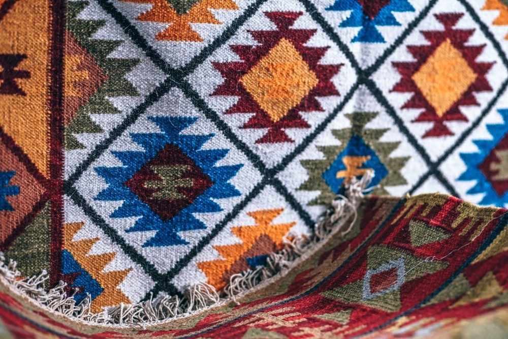 Red and Golden Traditional Indian Rug with another Vibrant Rug in the Background