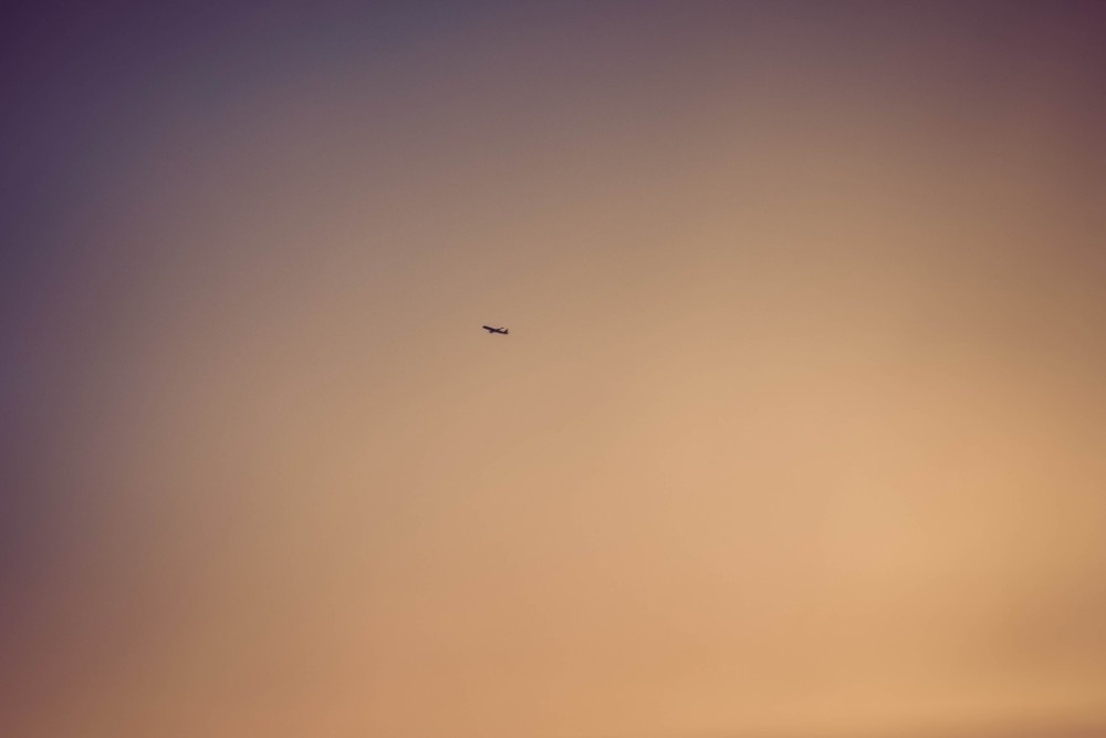 Airplane Flying Away in the Sunset
