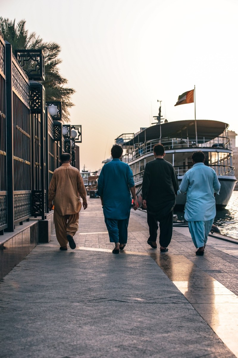 Four Men Walking along the Dubai Marina next to the Canal