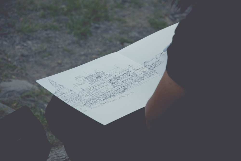 Man Drawing an Architecture Sketch on a Piece of Paper