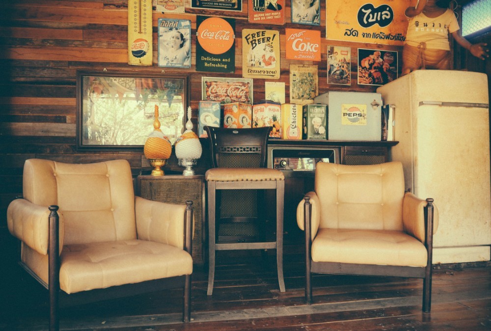 Retro Living Room with Two Chairs and Beverage Posters on the Wall behind them