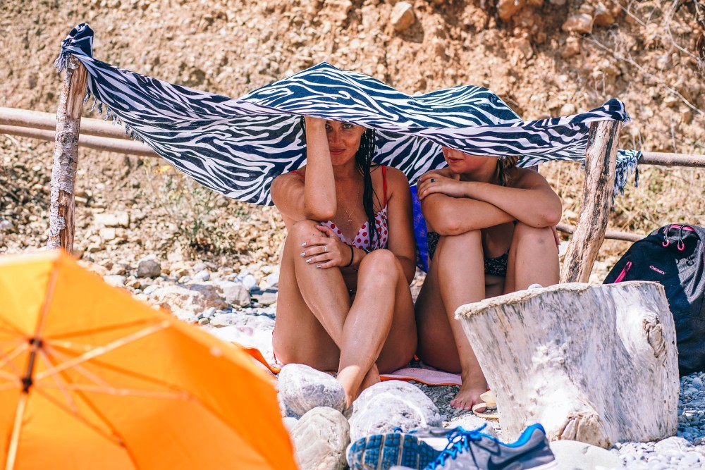 Two Girls under an Improvised Umbrella at the Beach