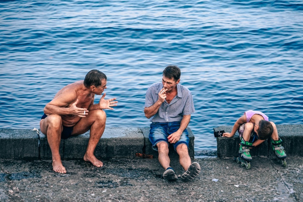 Two Men and a Kid Sitting By the Sea in Yalta