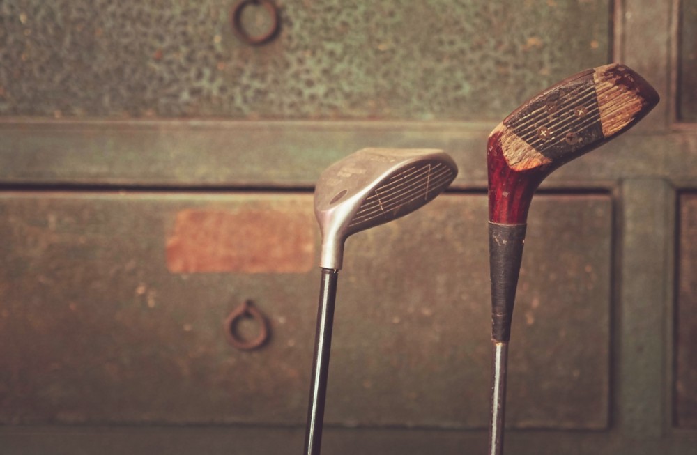 Vintage Golf Clubs in Front of a Wooden Drawer