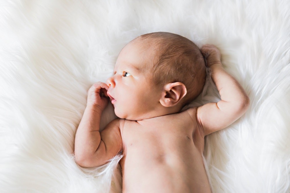 baby lying on white fur