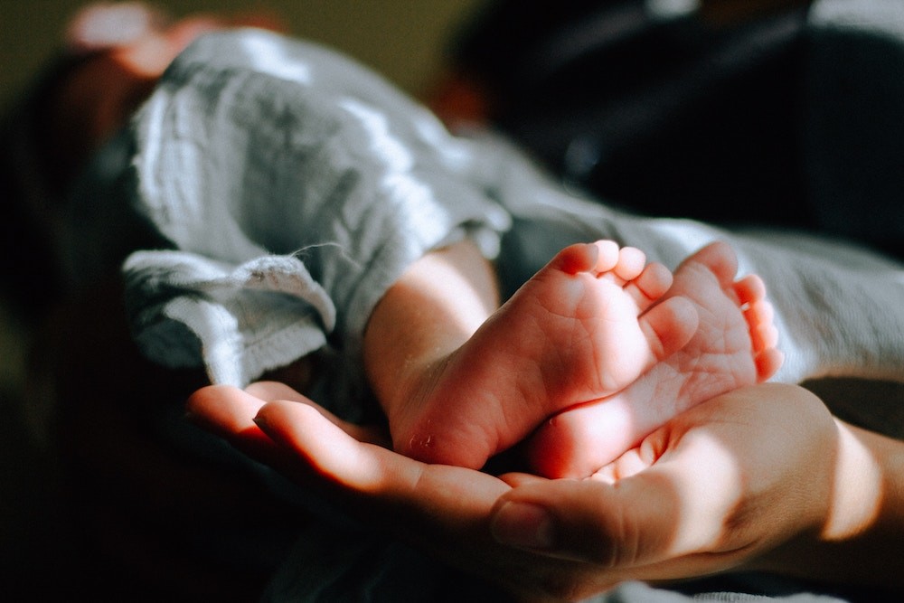 mom holding baby feet