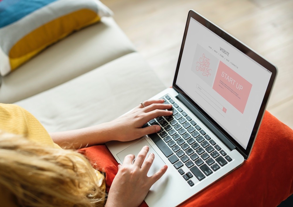 woman using MacBook Pro on her lap