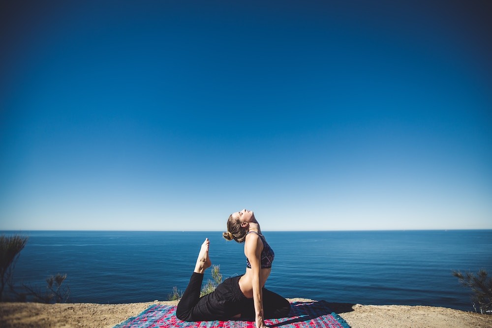 women doing a yoga next to the beach