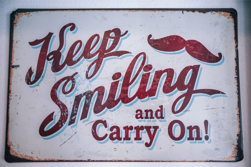 Café Sign Saying “Keep Smiling and Carry On”