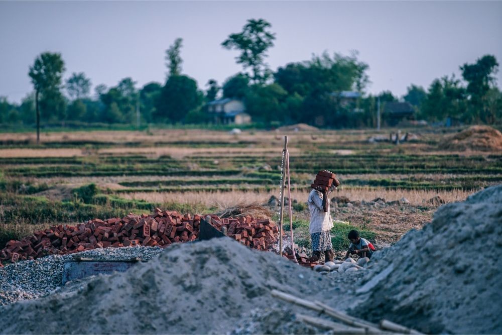 Grandpa and Grandson Moving Bricks at a Nepali Village