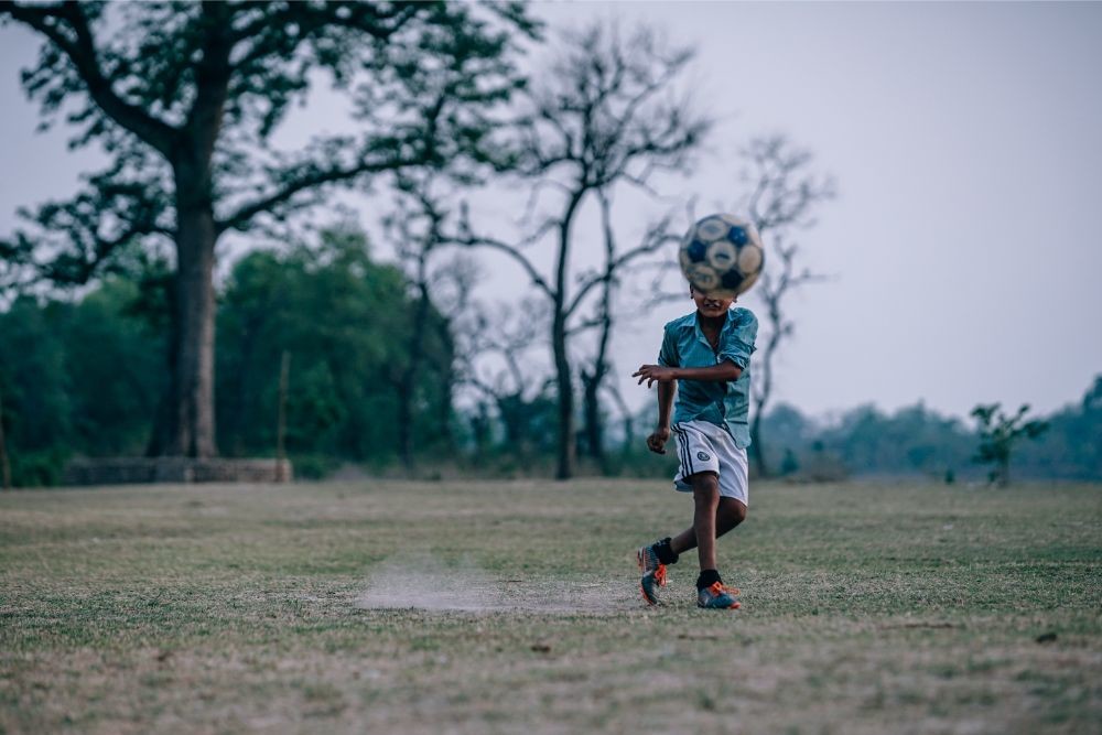 Nepali Boy Kicking a Ball towards the Camera