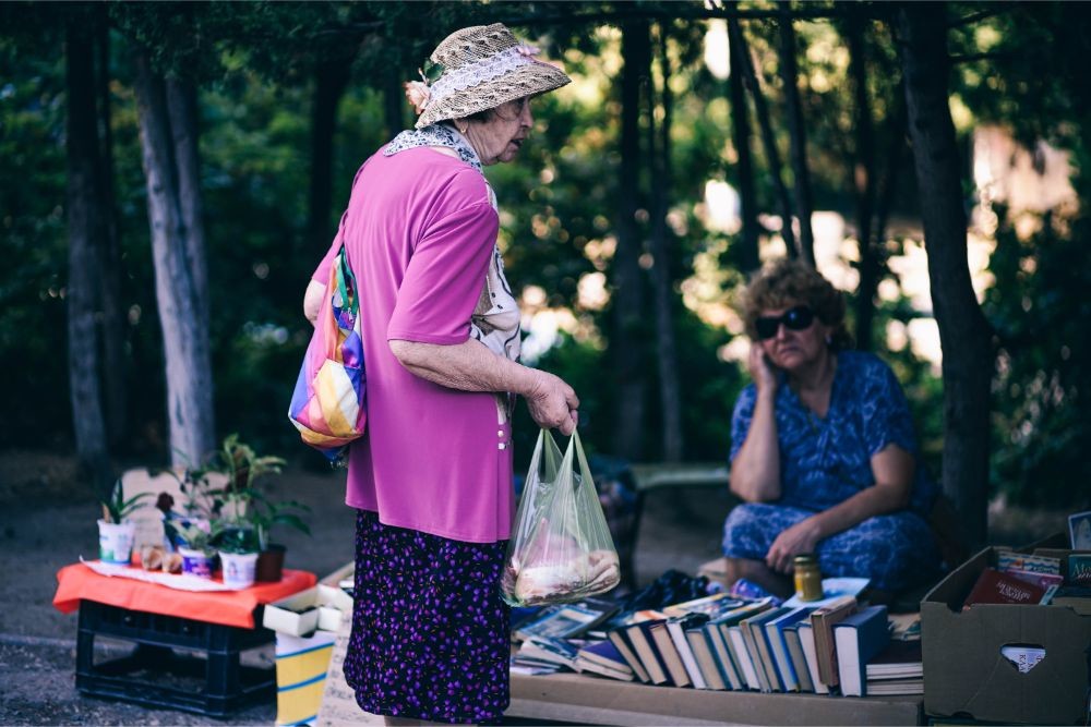 Old Lady Looking at an Outdoor Book Stand