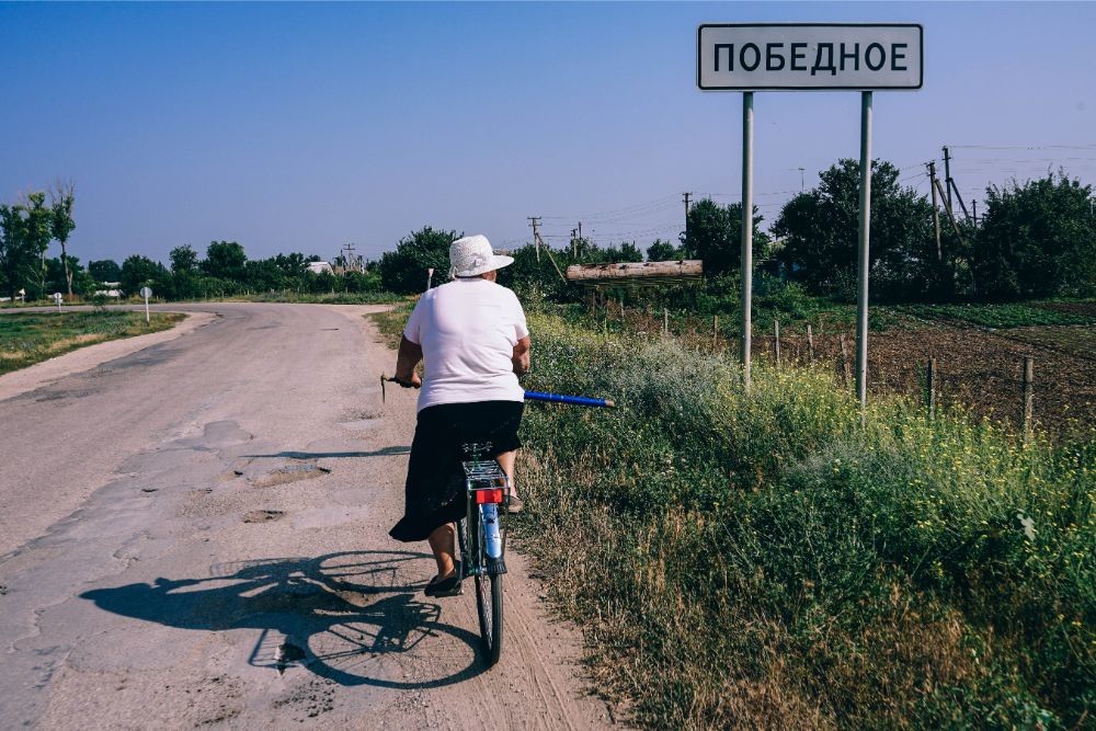 Older Woman Driving a Bicycle in a Country Side