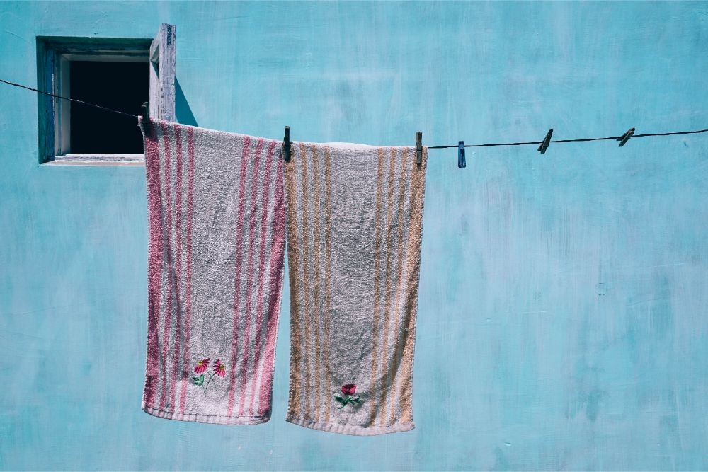 Towels Drying on a Cloth Drying Wire with a Big Light Blue Wall in the Background