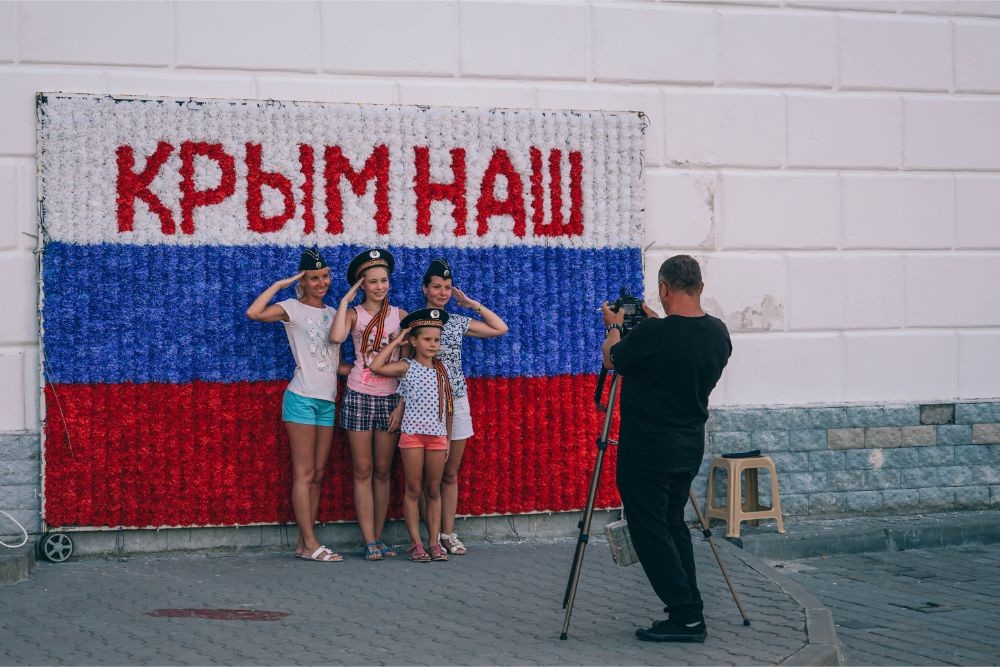 Young Girls Taking a Picture in front of a “Crimea is ours” Sign