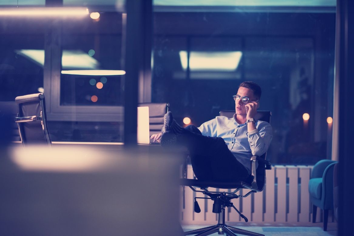 businessman using mobile phone in dark office PHZ