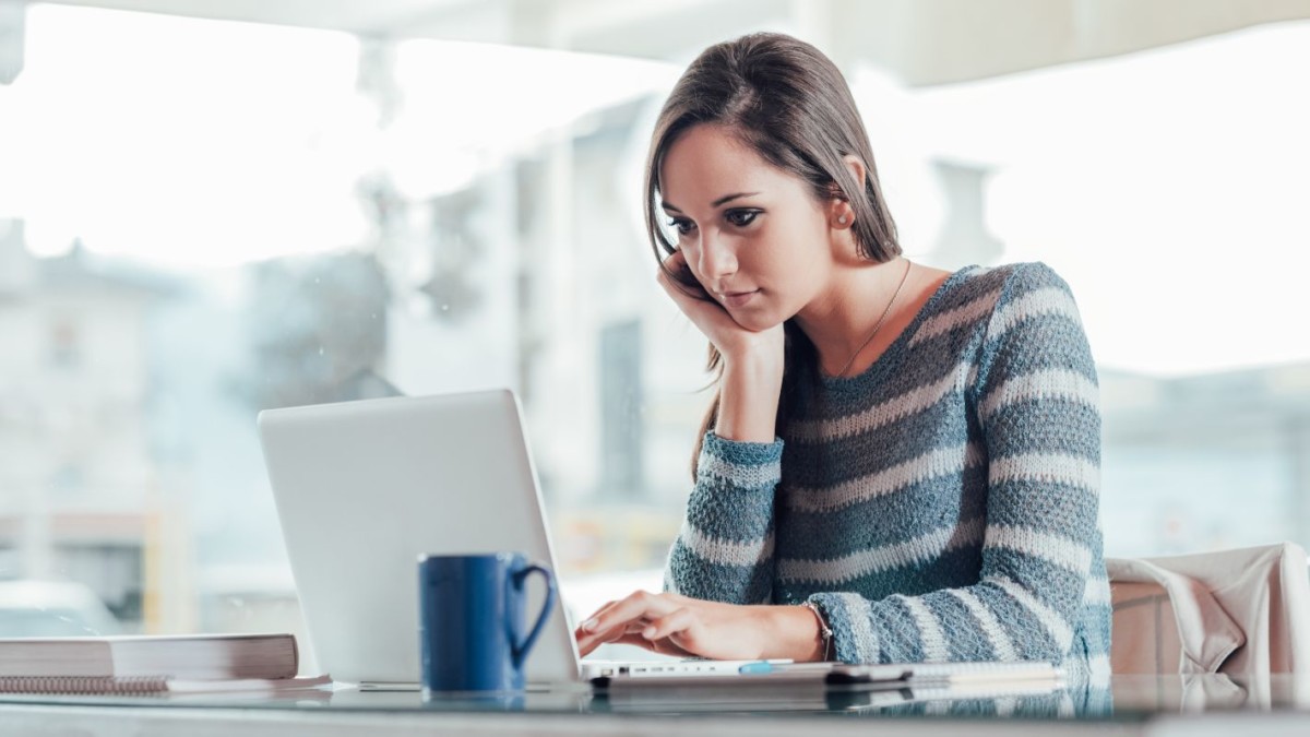 busy woman working with her laptop PQKULX