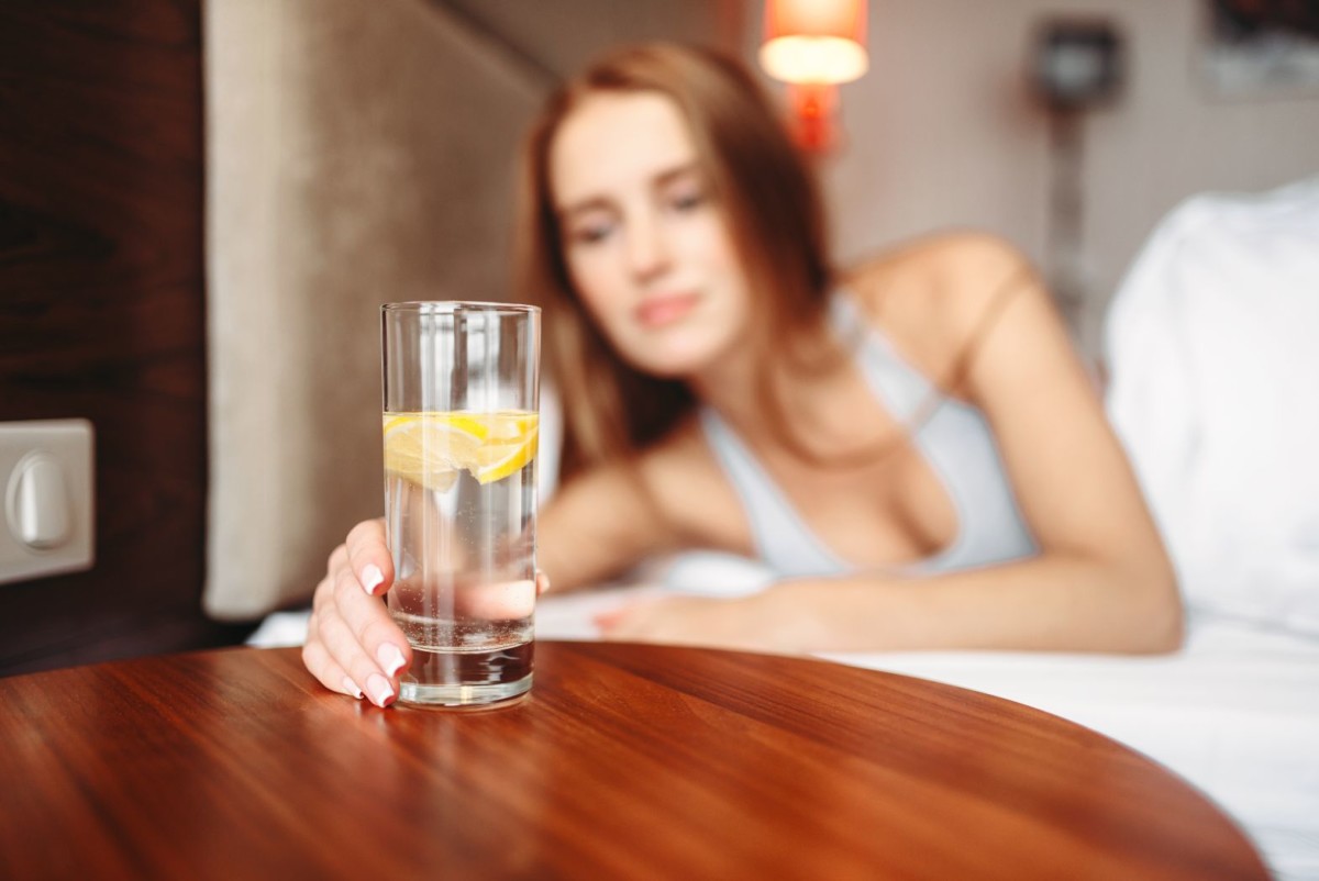 female hand holds glass with lemon water PBUAR