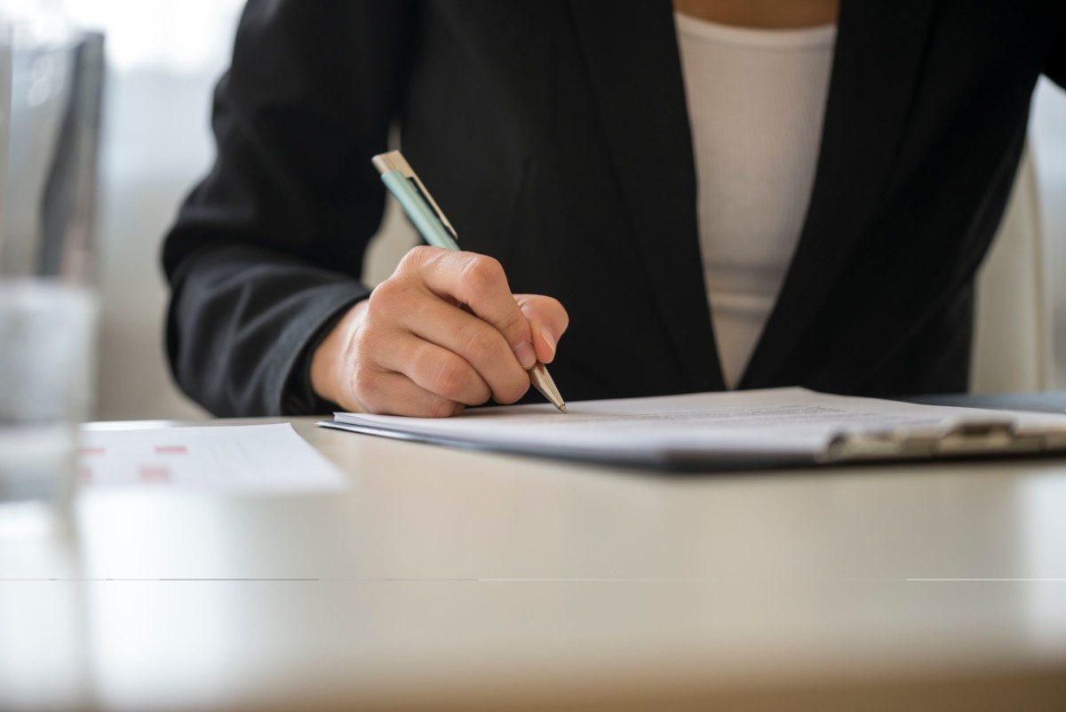 low angle view of a woman signing contract PNJAZ