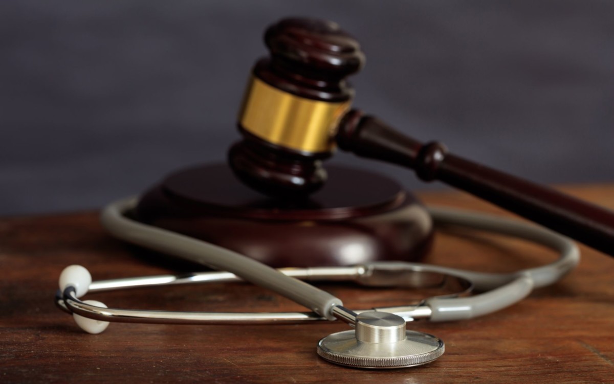 judge gavel and a stethoscope on a wooden desk PVVCT