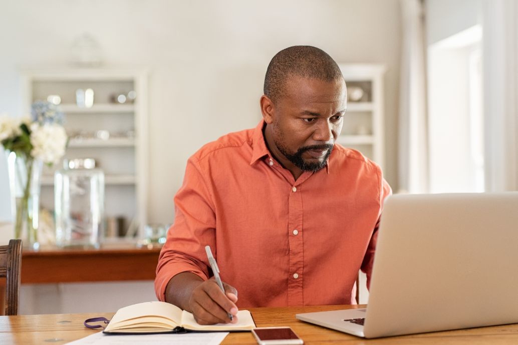 mature man working on laptop at home ZNBKW