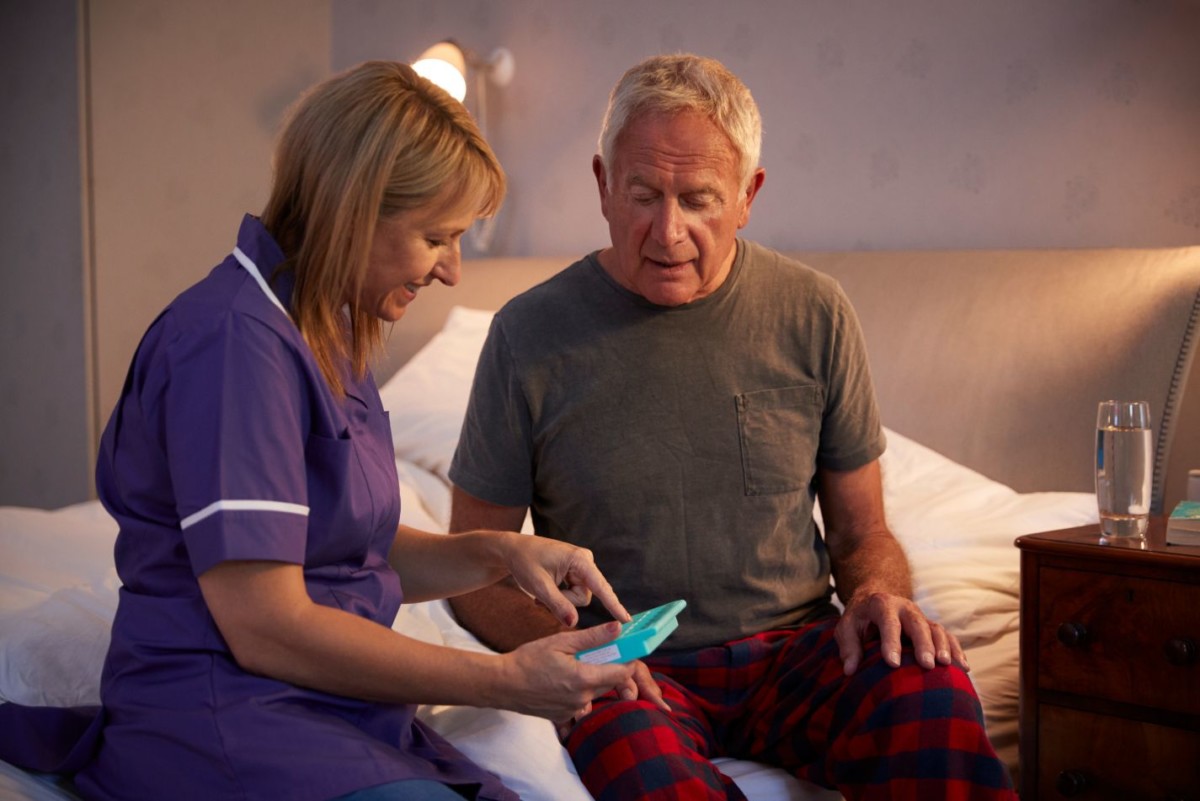 nurse helping senior man to organize medication PMRMCK