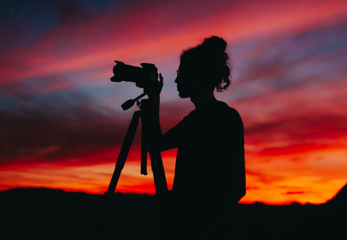 silhouette of woman holding camera at night