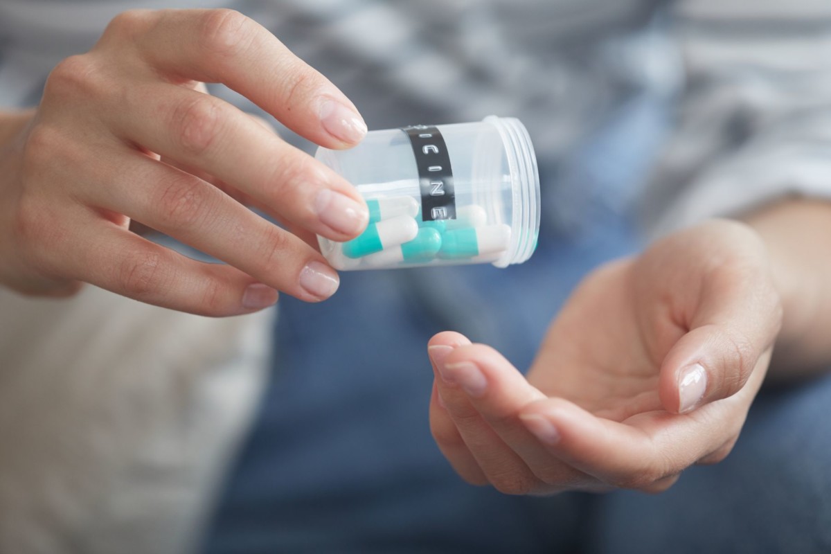 woman taking pills HKNDQ