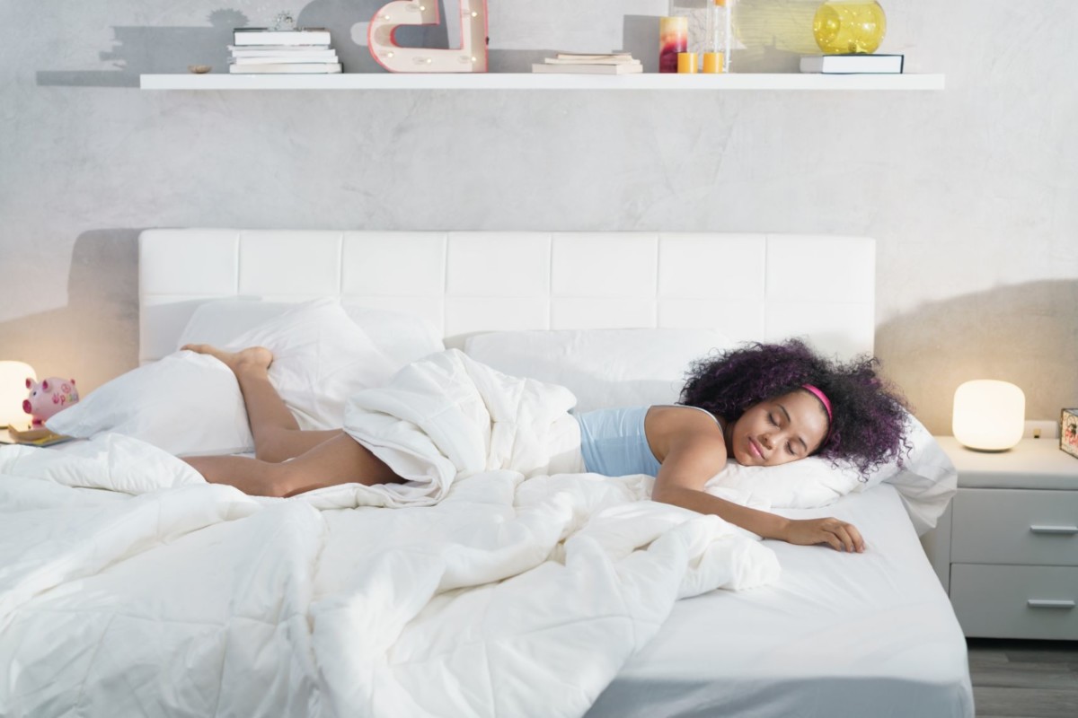 black woman sleeping alone in large bed NFHJE