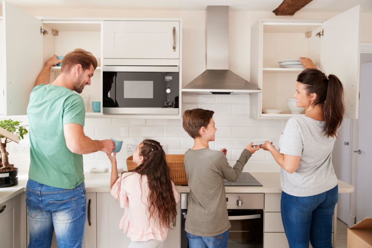 children helping to put away crockery in kitchen PTKA