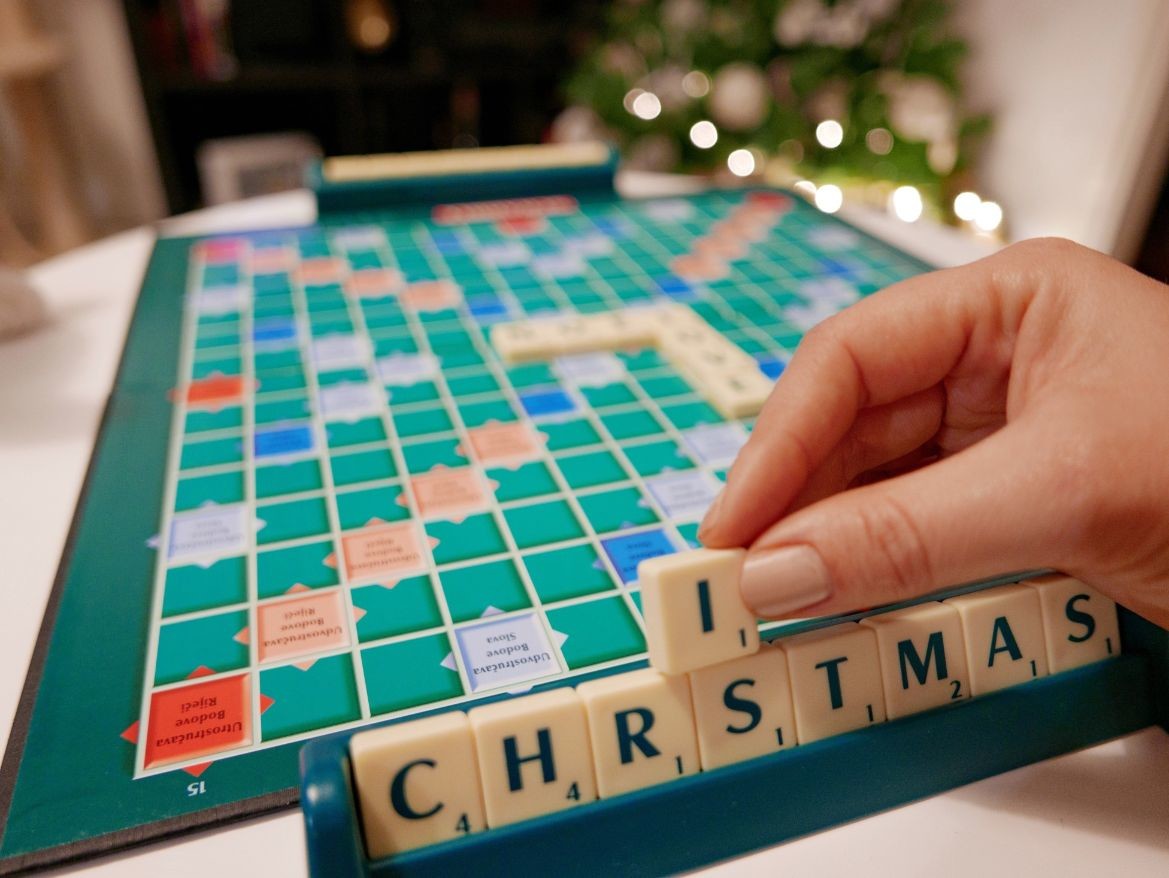 playing scrabble hand holding a scrabble letter letter tiles winter holidays christmas time christmas t kRJWZK