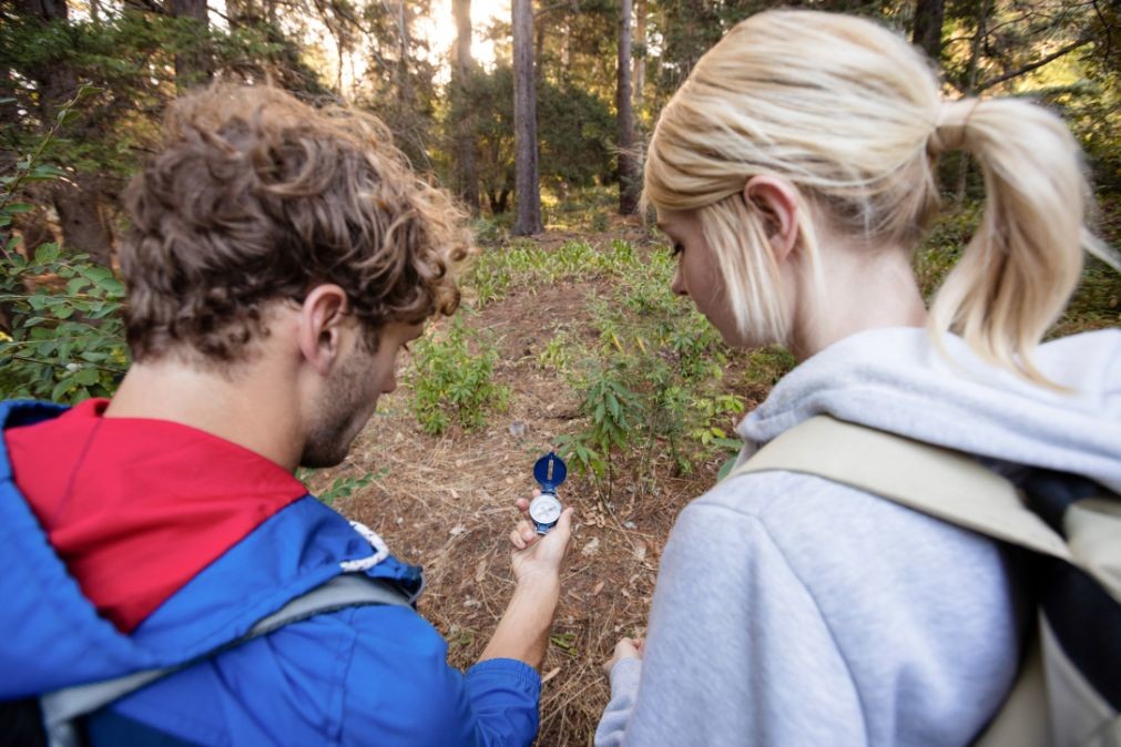 rear view of hiking couple checking the compass PAVKYE