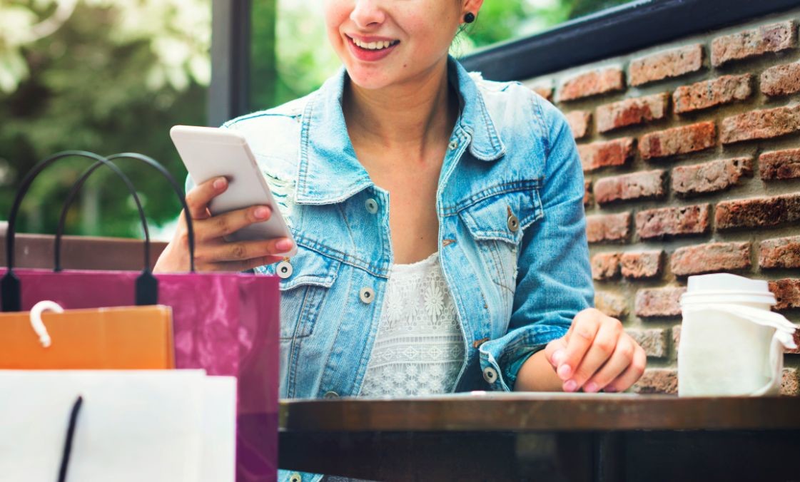 woman shopping outdoor mobile phone concept PWMFQJP