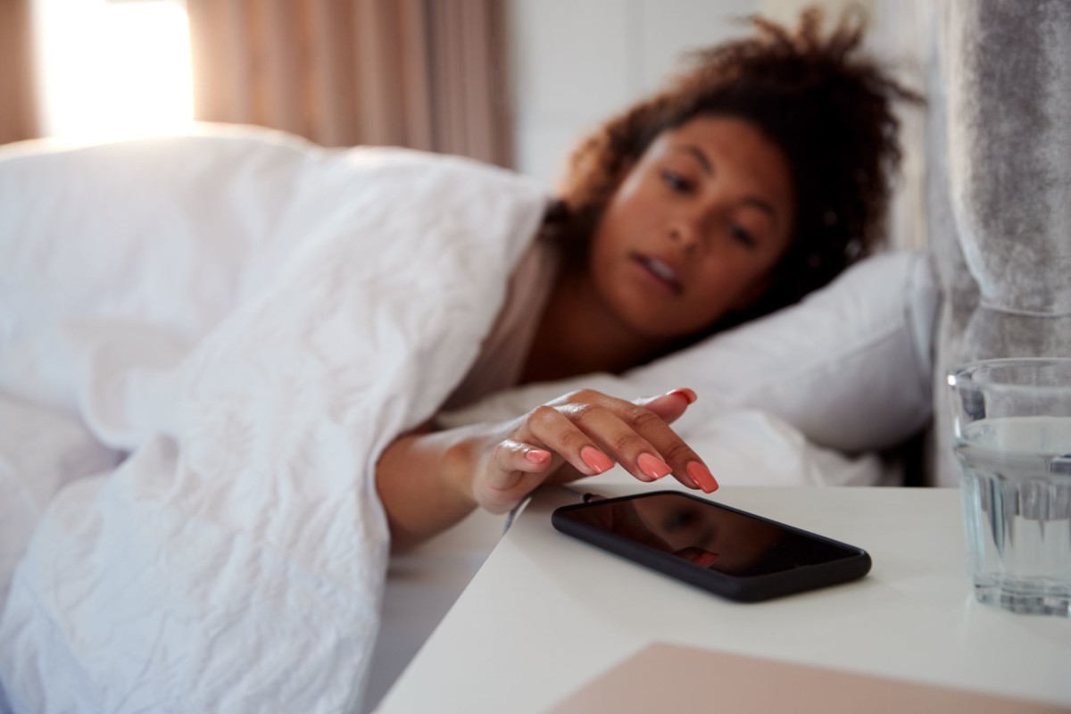 woman waking up in bed reaches out to turn off RSEMVY