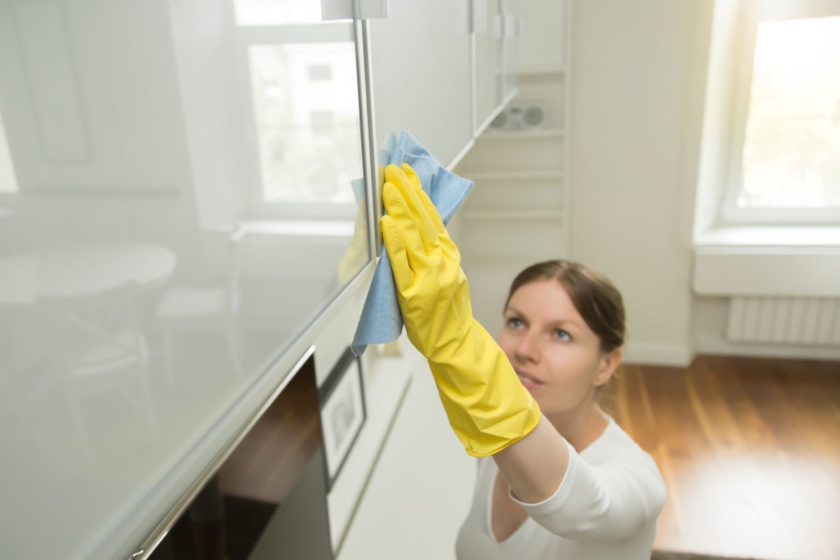 young attractive woman cleaning an upper surface PBDBDVM