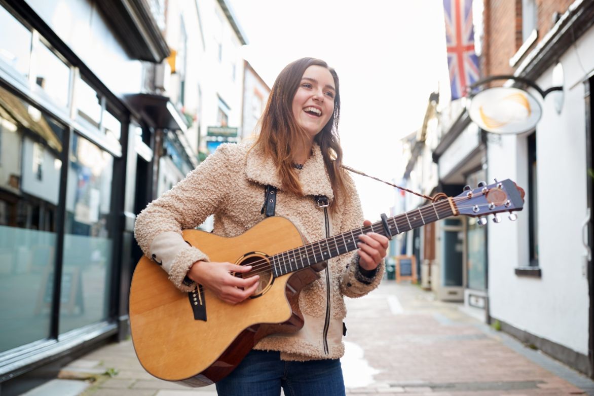 female musician busking playing acoustic guitar CWWHRB