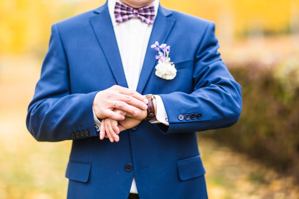 man in suit checking time on his wrist watch PZNJRGH