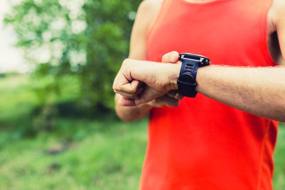 man running and checking sport smart watch PWATC