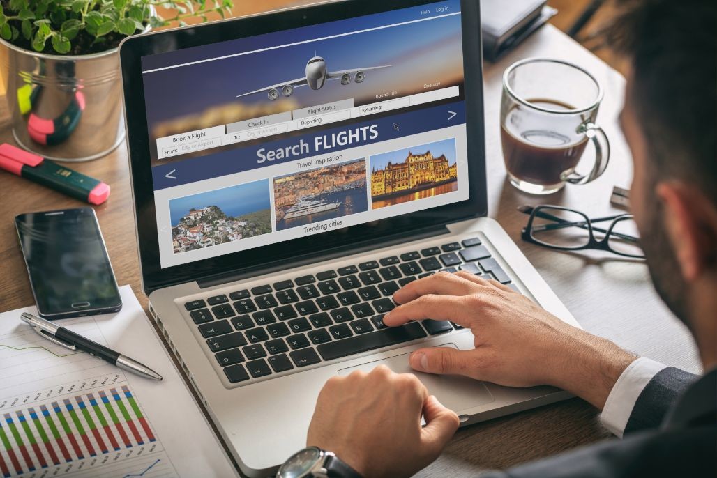 man working with a computer search flights on the GQUZ