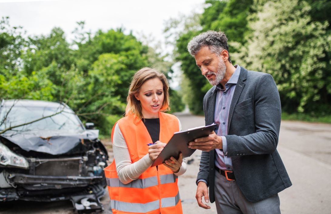 an insurance agent talking to a woman outside on AQJM