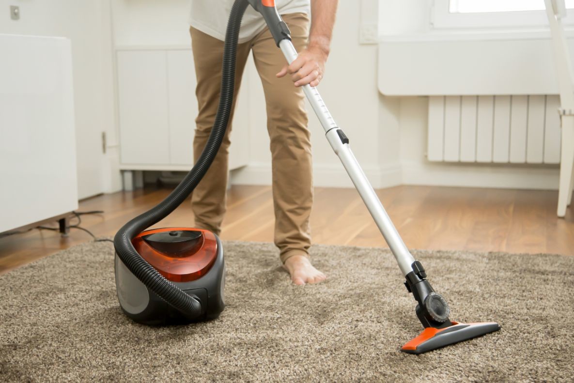 close up of man vacuum cleaning the carpet PHTXG