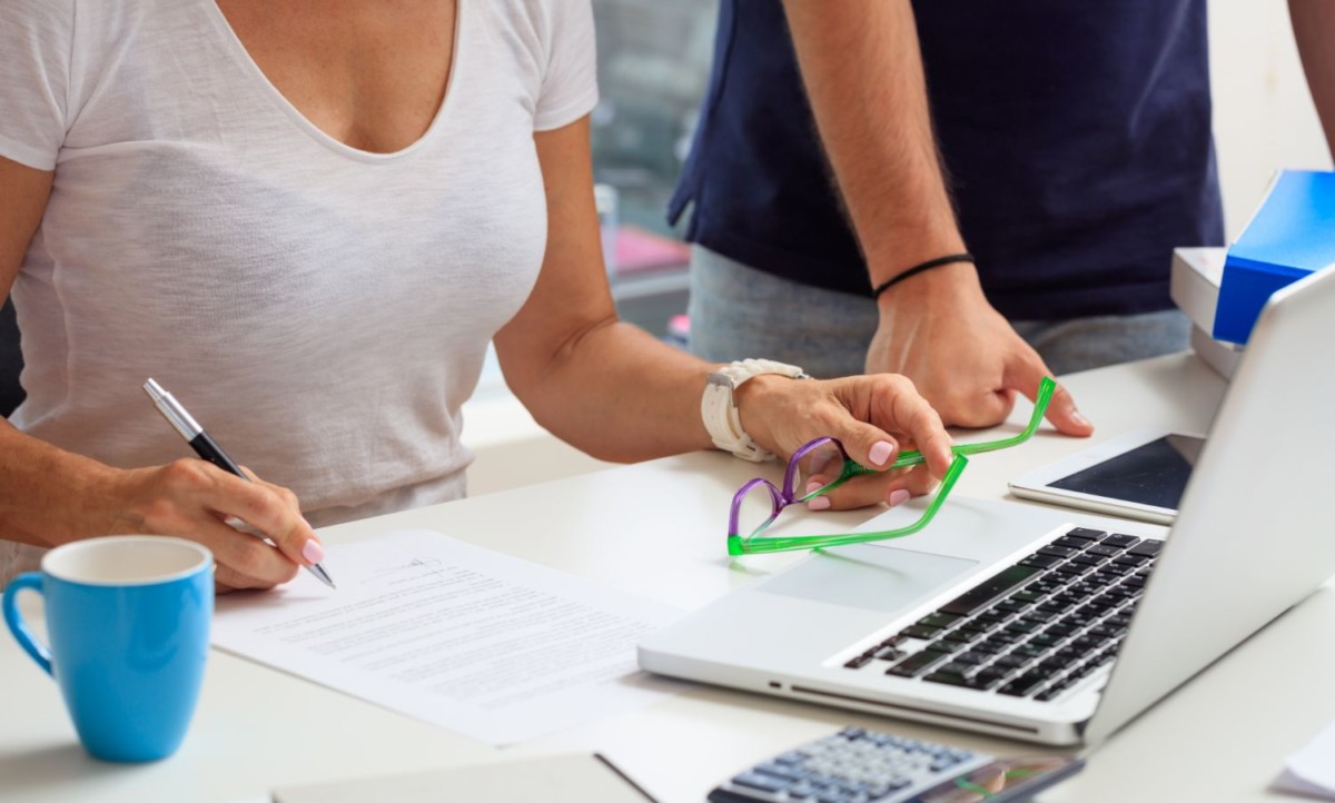 woman signing a contract in an office background PVGPZZB