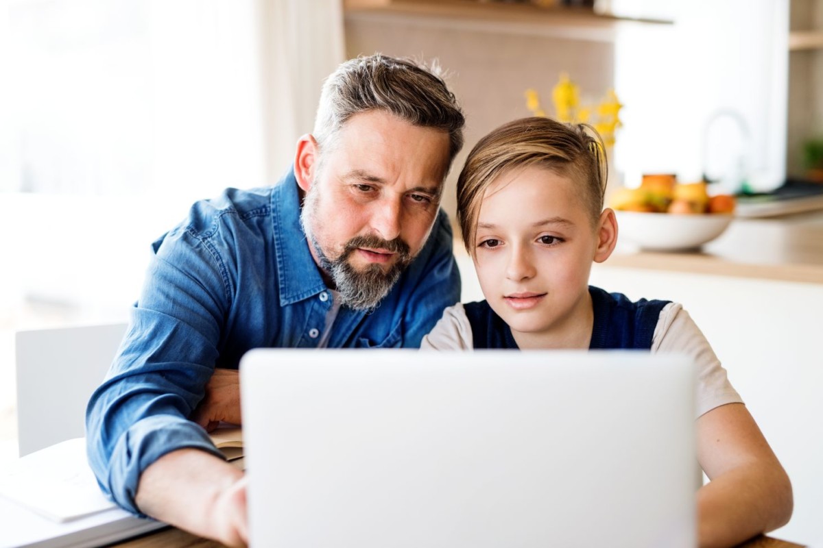 mature father with small son sitting at table indo VHYAZX