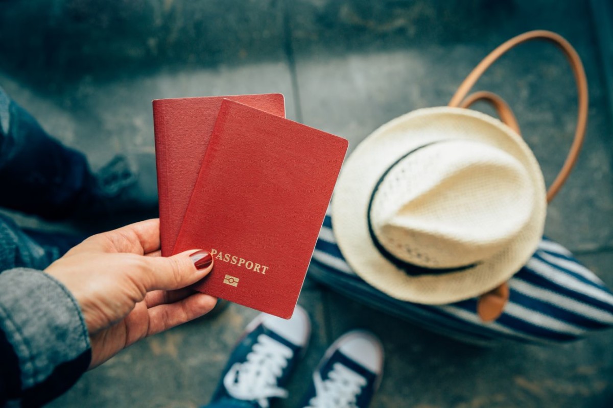 woman holding passports close up at airport PKEBEU