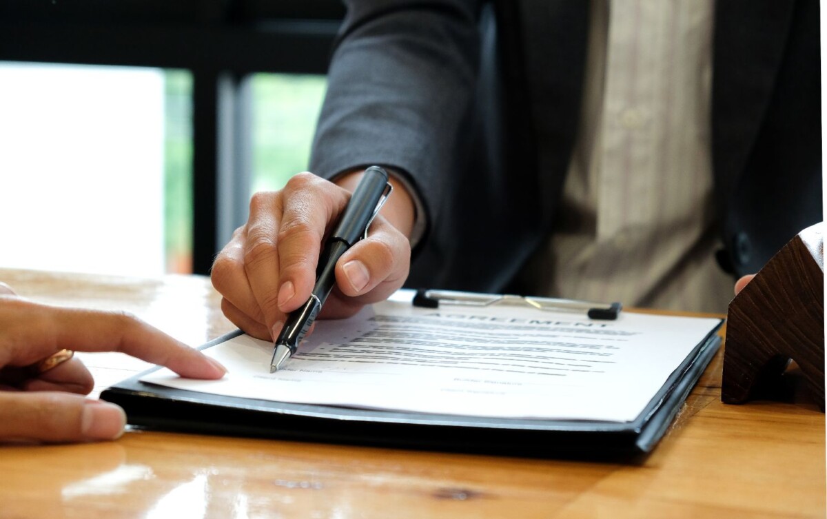 businessmen selling the house pointing at signing EMNZWTG