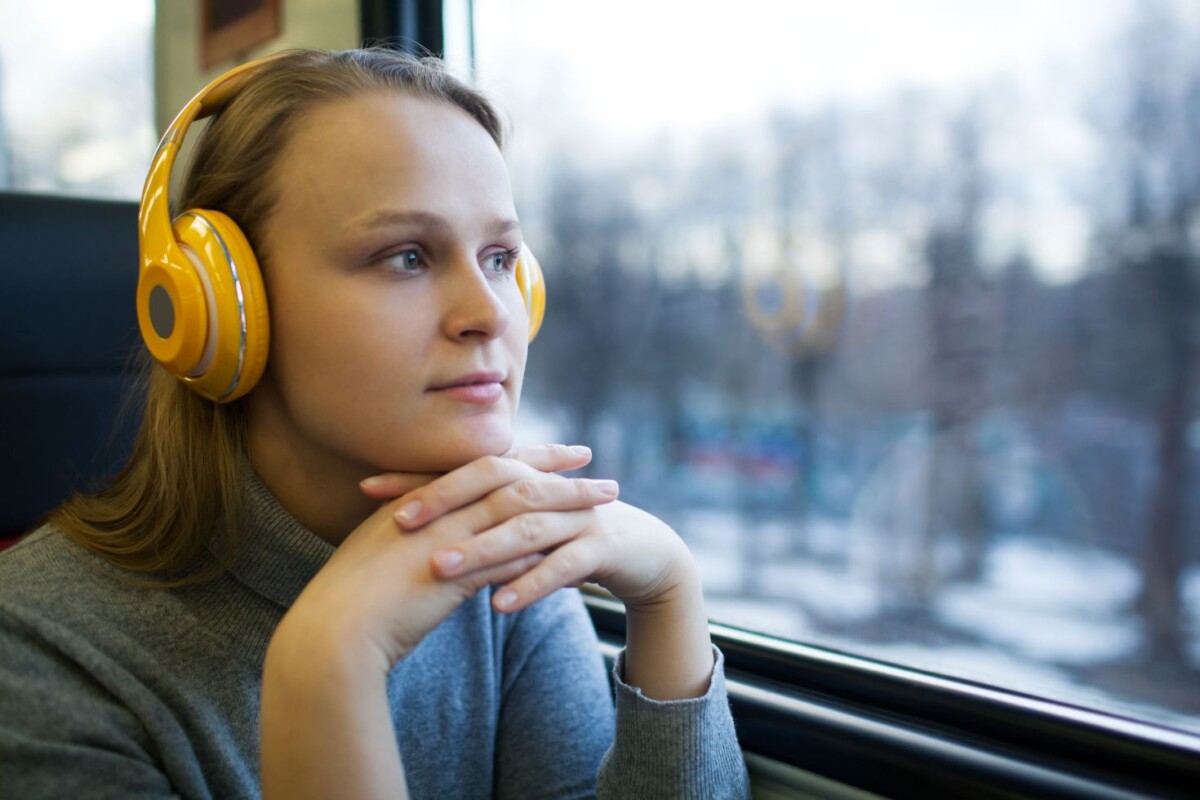 woman traveling by train with favorite music HFMD