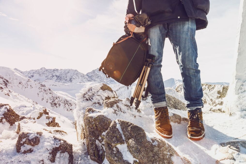 photographer traveler on a mountain top with equip pqz